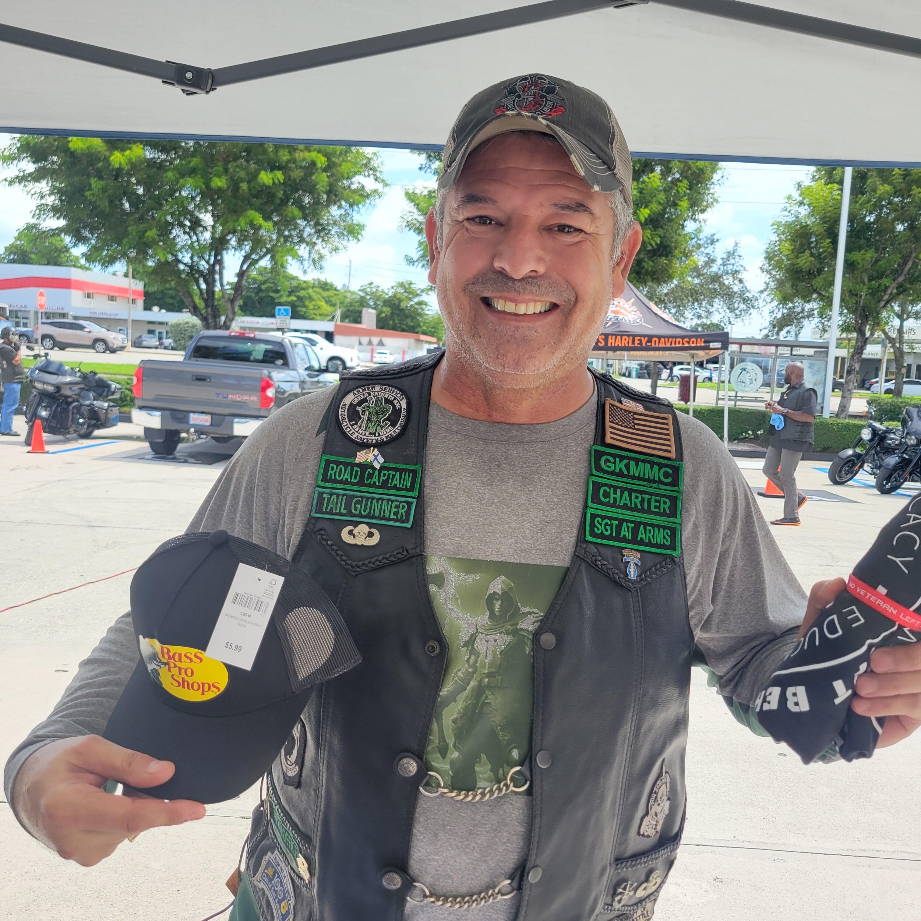 Veteran picking up his Vet Info No Veteran Left Behind Tee-Shirt and Bass Pro Hat.